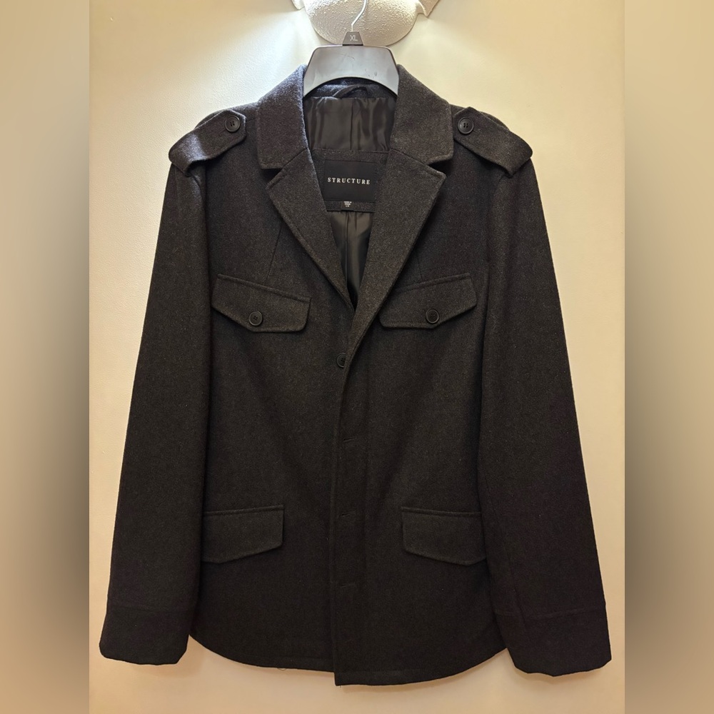 Men’s winter coat. Zip and button down. Pocket detail. Back split.